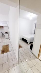 Una habitación blanca con una cama y un espejo. en fff, en Campinas