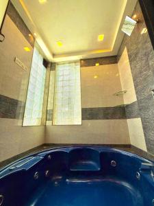 a large blue tub in a room with a window at Aashiyana Villa - The Dream Stays ll Jacuzzi ll Pvt Big Pool ll Garden ll 3 Ac Rooms ll Gazebo in Lonavala
