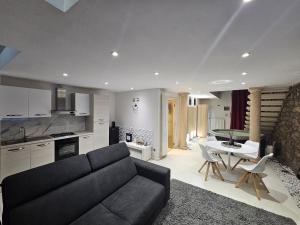 a living room with a black couch and a kitchen at White Loft & spa in Viterbo