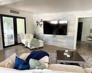 a living room with a couch and a flat screen tv at The Float House at Buckeye Lake - Hot Tub - Patio - Privacy in Thornville