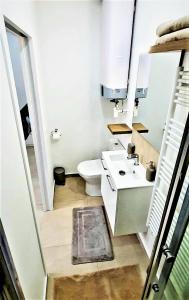 un bagno bianco con un water e un lavandino di Cosy et Chill studio Proche Paris et le Bourget , Ideal long séjour pour Couples et Professionnels a Drancy