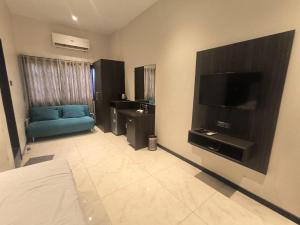 a living room with a blue couch and a television at Hotel Shubham Inn in Thane