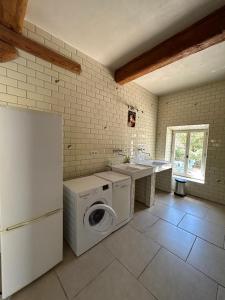 a kitchen with a washer and a sink and a refrigerator at Domaine Les Salices in Azille