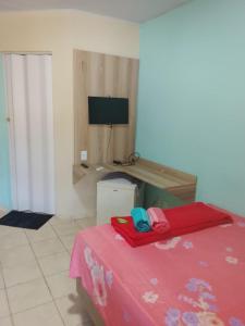 a room with a bed and a desk with a computer at Pousada Encantos de Paripueira in Paripueira +36 photos