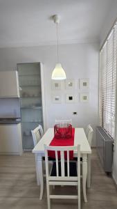 a kitchen with a white table with a red blanket on it at Foleza in Korçë