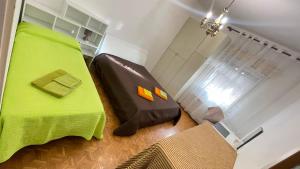 a bedroom with a bed with a green blanket at da Lilia in Salute&Bellezza Business Apartment in Monfalcone