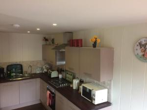 a kitchen with a microwave on a counter and a sink at Skye Lodge in Tighnabruaich