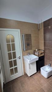a bathroom with a white sink and a toilet at Foleza in Korçë +5 photos