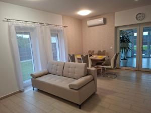 a living room with a couch and a table at Napsugár Wellness Apartman in Újudvar