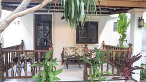 a porch of a house with a chair and a door at Maprang Boutique Stay in Nathon Bay