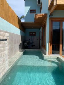 a swimming pool in the side of a house at Marlim-azul Loft in Prado