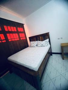 a bedroom with a wooden bed in a room at Osim Bnb in Arusha +9 photos