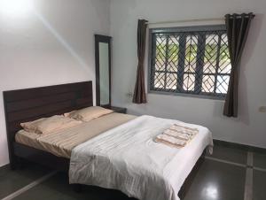 a bedroom with a large bed with a window at Peace Villa with pool in Murud