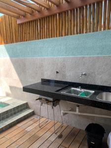 a bathroom with a sink and a wooden floor at Marlim-azul Loft in Prado +46 photos