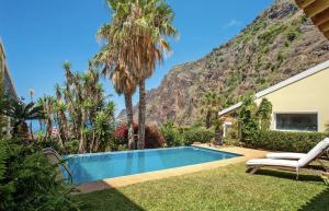 a villa with a swimming pool in front of a mountain at Suite Bela Vigia 3 in Jardim do Mar