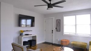 a living room with a ceiling fan and a fireplace at Mini Boutique Hotel - THE ELLA by EVRH in Daytona Beach