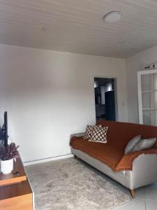 a living room with a brown couch and a table at Casa em Petrópolis in Petrópolis