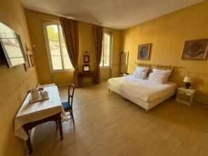 a hotel room with a bed and a table at Hôtel Riquet in Toulouse