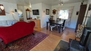 a living room with a red couch and a table at Gästhus i Röjdåfors in Östmark