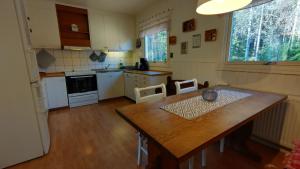 a kitchen with a wooden table and a dining room at Gästhus i Röjdåfors in Östmark