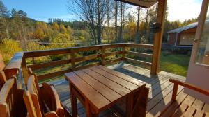 a wooden deck with a wooden table and chairs at Gästhus i Röjdåfors in Östmark