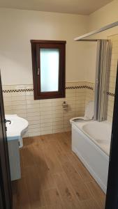 Un baño con bañera blanca y lavabo. en Holiday House Iolo, en Prato