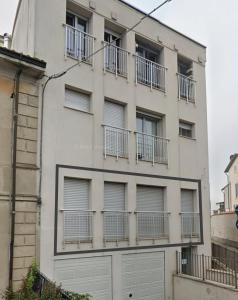 Un edificio blanco con balcones a los lados. en Holiday House Iolo, en Prato