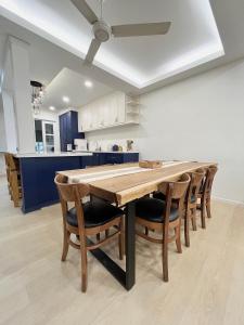 a kitchen with a wooden table and chairs at Roomah Puteh in Shah Alam +13 photos