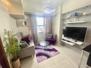 a living room with a couch and a flat screen tv at Horizons 101 Condominium in Cebu City