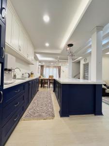 a large kitchen with blue cabinets and a large island at Roomah Puteh in Shah Alam