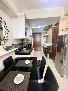 a kitchen with a black table and black chairs at Horizons 101 Condominium in Cebu City
