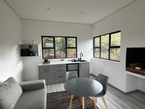 a living room with a table and a kitchen at Coddiwomple Cabins in Tulbagh