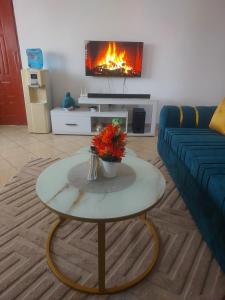 a living room with a couch and a table with flowers at Rhoda Homestay in Diani Beach