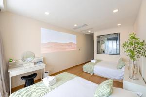上海市にある梧舍壹号 外滩百年公寓B&B -Riverside Grace Suites on the bund and metro stationのベッドルーム1室(ベッド2台、鏡付きデスク付)