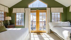 Dos camas en una habitación con paredes y ventanas verdes. en Vail View by AvantStay Minutes from Beaver Creek, en Dowds Junction