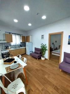 a living room with a table and chairs and a kitchen at Leonidio Downtown Haven in Leonidion