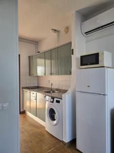 een keuken met een wasmachine en een koelkast bij Europe Sun Bungalow in Maspalomas +6 foto's