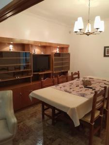a dining room with a table and a television at Espacio Comodoro P in Comodoro Rivadavia