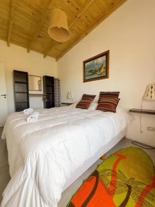 a bedroom with a large white bed in a room at Lalau Casa de Playa in Chapadmalal