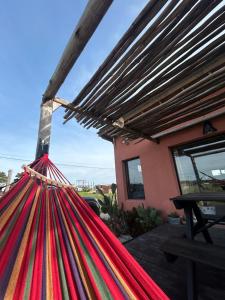 a red hammock in front of a house at Lalau Casa de Playa in Chapadmalal