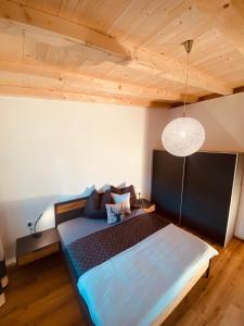 Un dormitorio con una cama grande con techo de madera. en Apartment Bergfieber, en Fieberbrunn