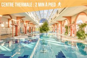 a large swimming pool in a building with people in it at Cocon - Hyper Centre - Clim - Wifi in Dax