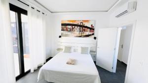 een witte kamer met een bed en een schilderij aan de muur bij Pipa Costa in Costa Teguise +17 foto's