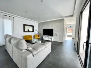 een woonkamer met een bank en een televisie bij Pipa Costa in Costa Teguise