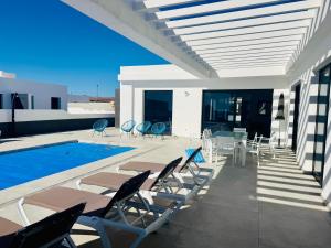 een terras met stoelen en een zwembad bij Pipa Costa in Costa Teguise