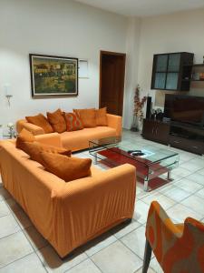 - un salon avec deux canapés orange et une table dans l'établissement Restful house in Patras, à Patras