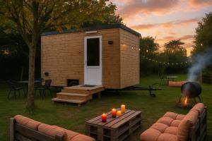 蓬沙托La Tiny Roulotte的院子里有一间带烤架和蜡烛的小房子