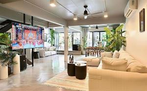 Una sala de estar con sofás y un televisor de pantalla plana. en SunMui Pool Villa - 7 Bedrooms - Old town, en Chiang Mai