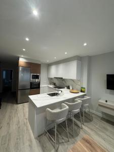 a kitchen with a sink and some chairs in it at Refugio moderno céntrico in Vigo