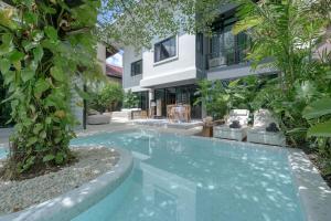 a swimming pool in front of a building at SunMui Pool Villa - 7 Bedrooms - Old town in Chiang Mai